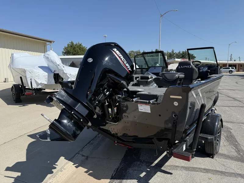 The Image of 2025 Lund 1775 Impact XS boat with Mercury outboard motor, parked outdoors. - 0