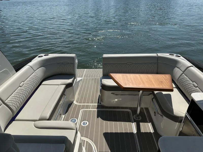 Slide: The Image of 2024 Sea Ray Sundancer 370 boat interior with elegant seating and wooden table on water. - 23