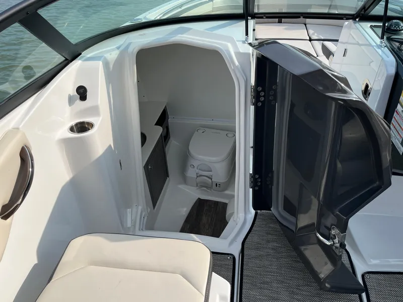 Slide: The Image of 2021 Monterey M6 boat interior with open compartment and portable toilet. - 6
