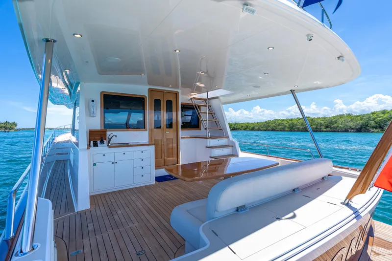 Slide: The Image of Luxurious 2018 Grand Banks GB60 yacht deck with seating, table, and ocean view. - 11