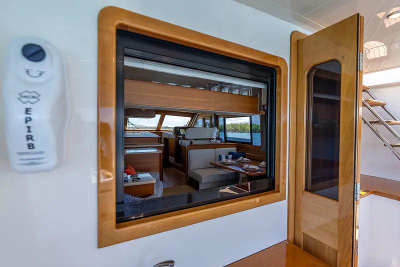 Slide: The Image of Interior view of 2018 Grand Banks GB60 yacht, featuring elegant wood finishes and dining area. - 23