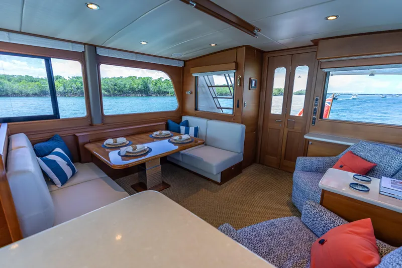 Slide: The Image of Luxurious 2018 Grand Banks GB60 yacht interior with elegant dining area and scenic water views. - 24