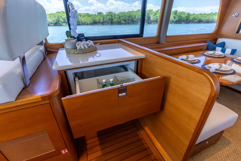 Slide: The Image of Luxurious 2018 Grand Banks GB60 yacht interior with open drawer fridge and elegant dining setup. - 39