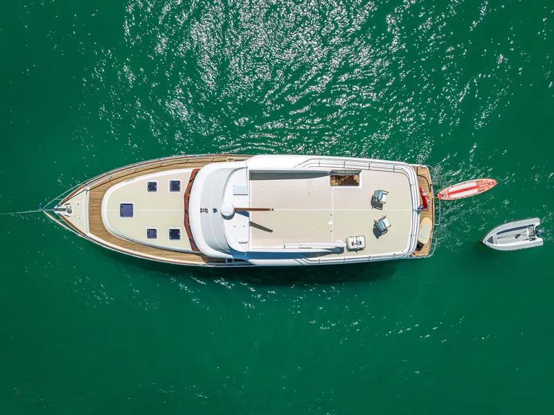 Slide: The Image of 2018 Grand Banks GB60 yacht cruising on blue water near a tropical shoreline. - 87