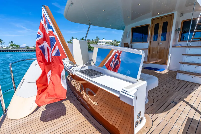 Slide: The Image of 2018 Grand Banks GB60 yacht deck with flag, TV, and ocean view. - 9