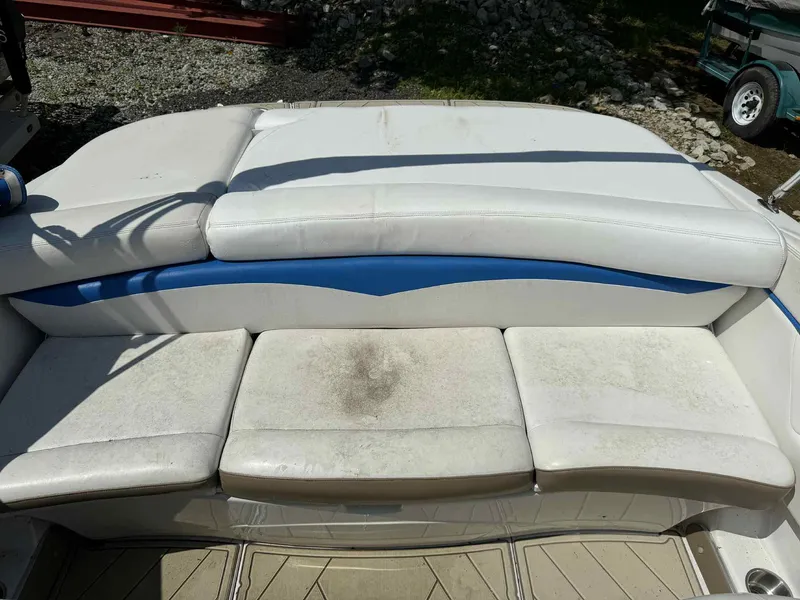 Slide: The Image of 2008 Four Winns 200 Horizon boat seating with white and blue upholstery, slightly weathered. - 17