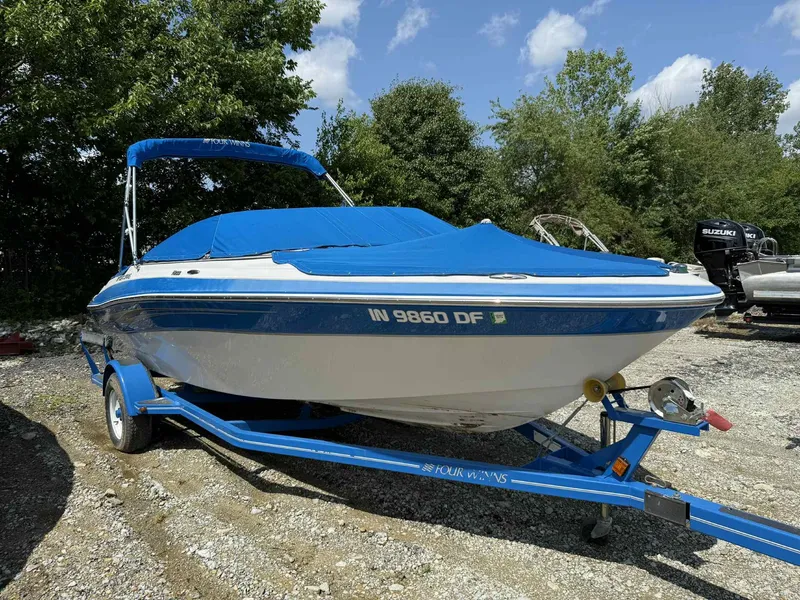 Slide: The Image of 2008 Four Winns 200 Horizon boat with blue cover on trailer, parked outdoors. - 2