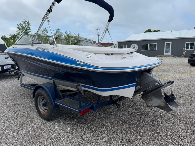 Slide: The Image of 2008 Four Winns H200 boat on trailer, blue and white, parked on gravel. - 5
