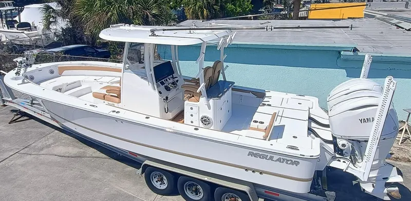 Slide: The Image of 2025 Regulator 30XO boat with Yamaha engines on a trailer, parked outdoors. - 1