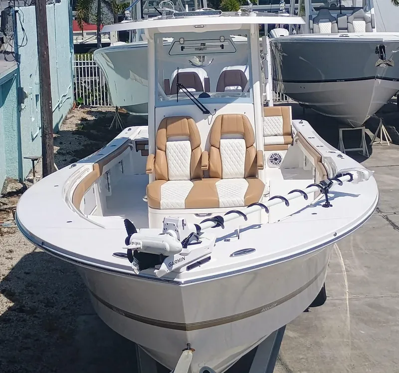 Slide: The Image of 2025 Regulator 30XO boat with tan seating, docked outdoors. - 2