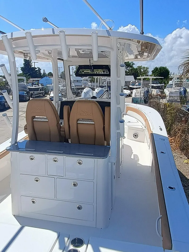 Slide: The Image of 2025 Regulator 30XO boat interior with dual seats and storage drawers under a clear blue sky. - 6