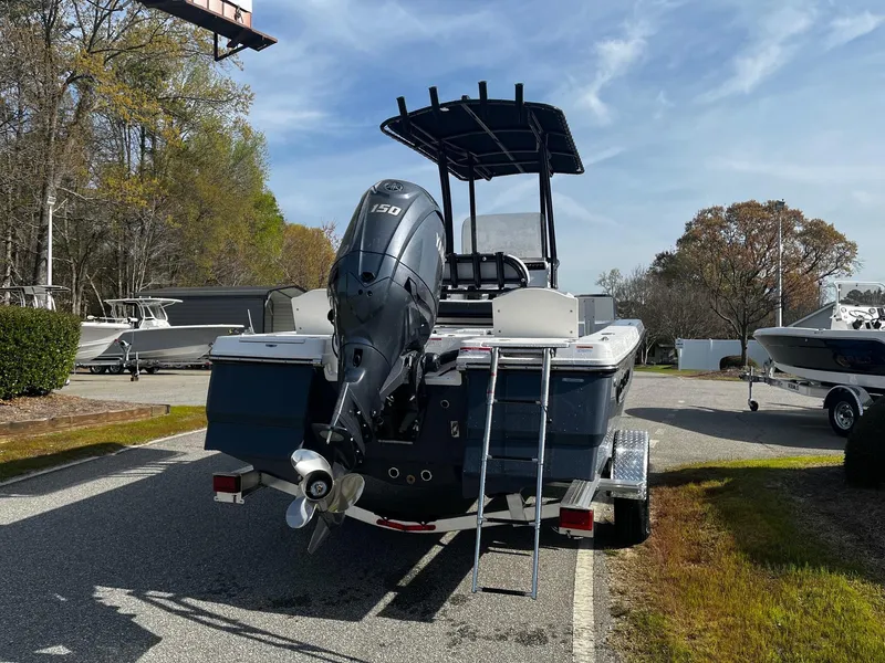 Slide: The Image of 2025 Robalo 206 Cayman boat with outboard motor on trailer, parked outdoors. - 10