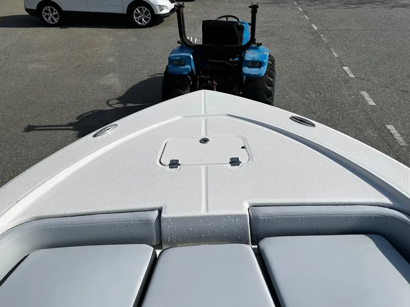 Slide: The Image of 2025 Robalo 206 Cayman boat on trailer, towed by blue tractor. - 6