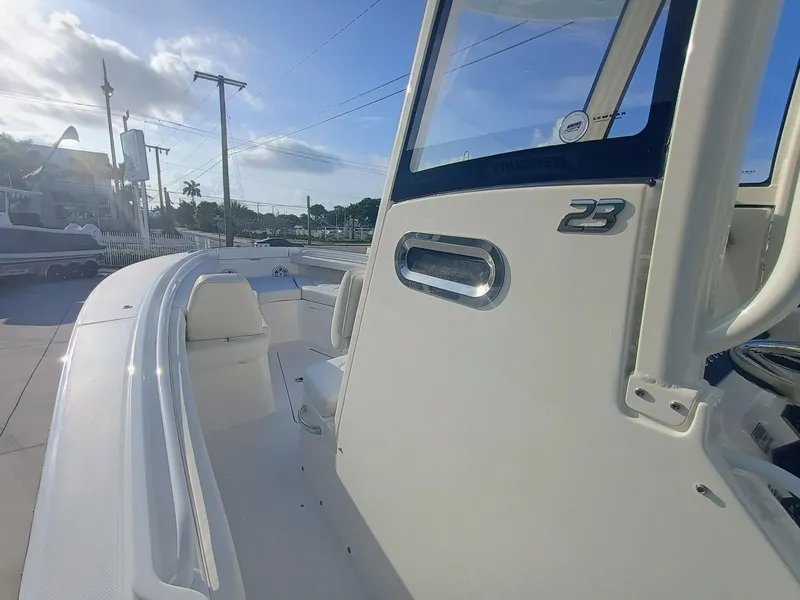 Slide: The Image of 2025 Regulator 23 boat, sleek design, white exterior, sunny day, marina background. - 18