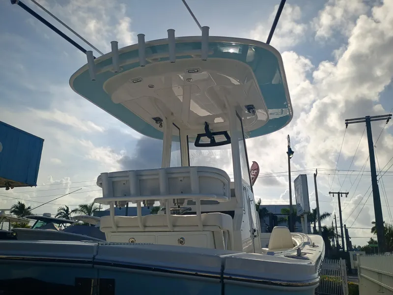 Slide: The Image of 2025 Regulator 23 boat with T-top against a cloudy sky background. - 21