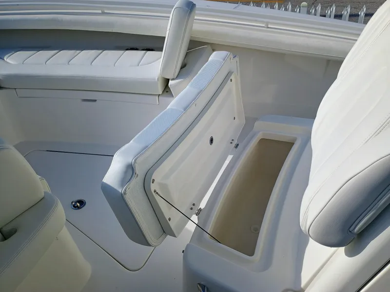 Slide: The Image of 2025 Regulator 23 boat interior with open storage compartment and white seating. - 25