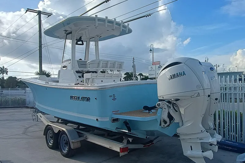 Slide: The Image of 2025 Regulator 23 boat with Yamaha engines on a trailer, parked outdoors. - 3