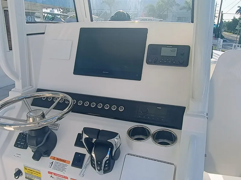 Slide: The Image of 2025 Regulator 23 boat dashboard with steering wheel, Garmin display, and control panel. - 32