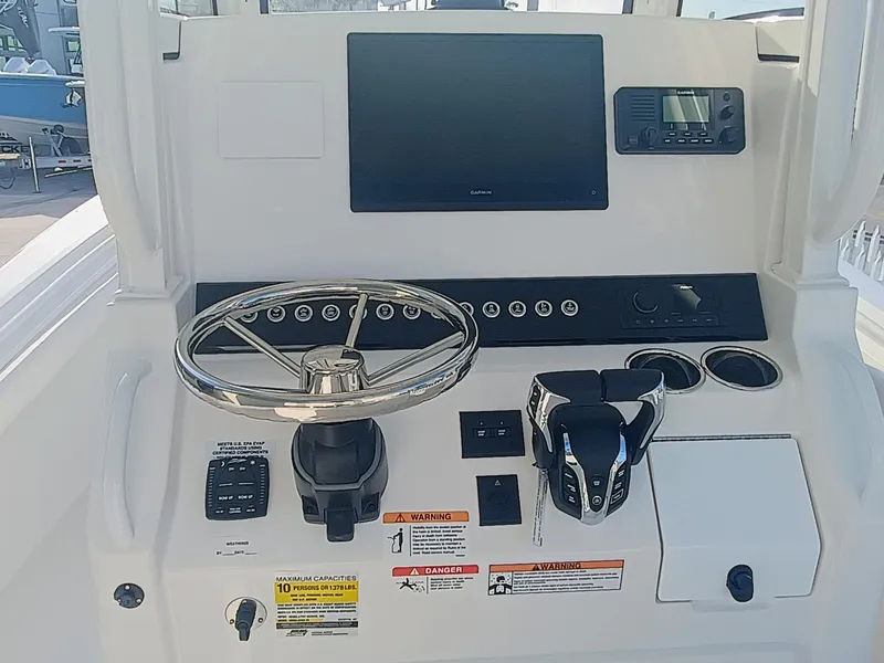Slide: The Image of 2025 Regulator 23 boat dashboard with steering wheel, controls, and navigation display. - 7