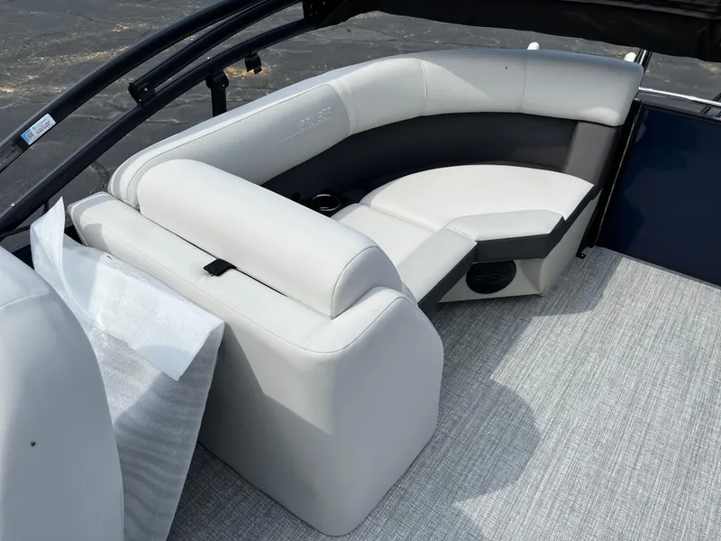 Slide: The Image of 2026 Harris Cruiser 210 boat interior with white cushioned seating and gray flooring. - 10