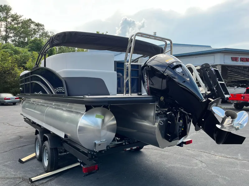 Slide: The Image of 2026 Harris Cruiser 210 pontoon boat on trailer, featuring a powerful outboard motor. - 4