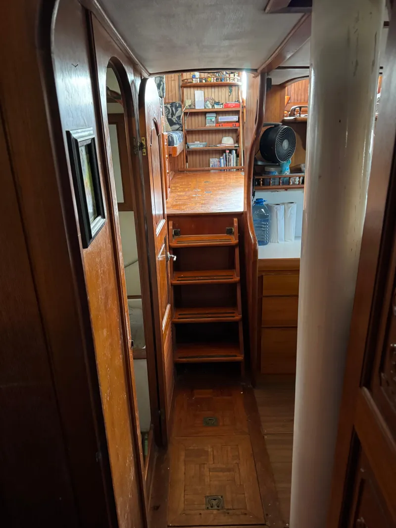 Slide: The Image of Interior of 1983 Island Trader Motor Sailor with wooden stairs and shelves. - 17