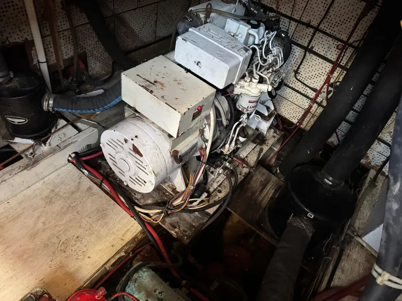 Slide: The Image of Engine room of a 1983 Island Trader Motor Sailor with visible machinery and wiring. - 30