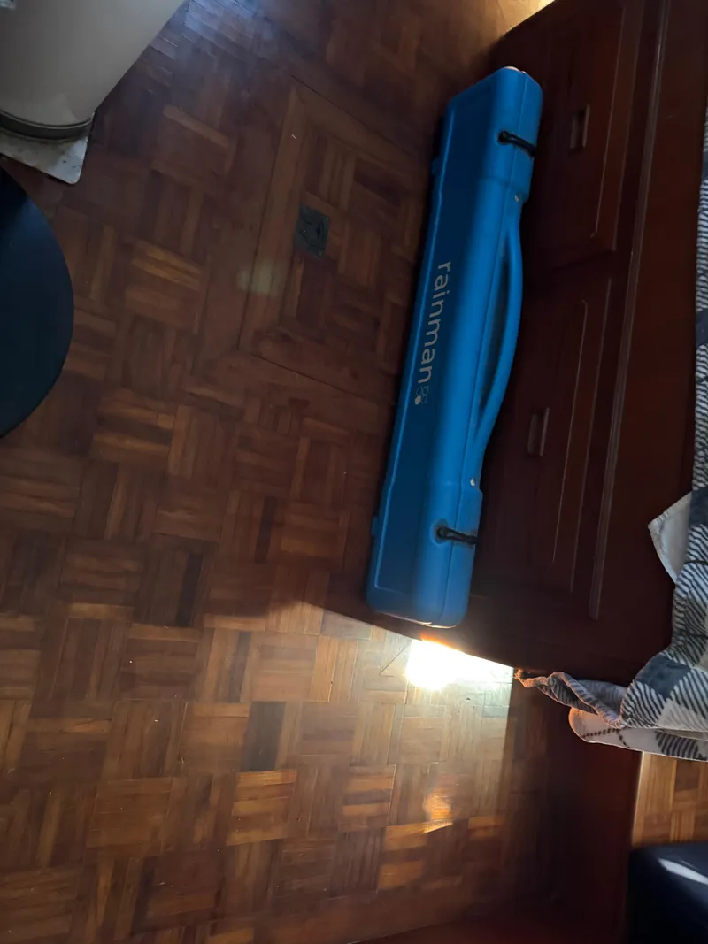 Slide: The Image of Blue Rainman case on wooden floor inside 1983 Island Trader Motor Sailor. - 33