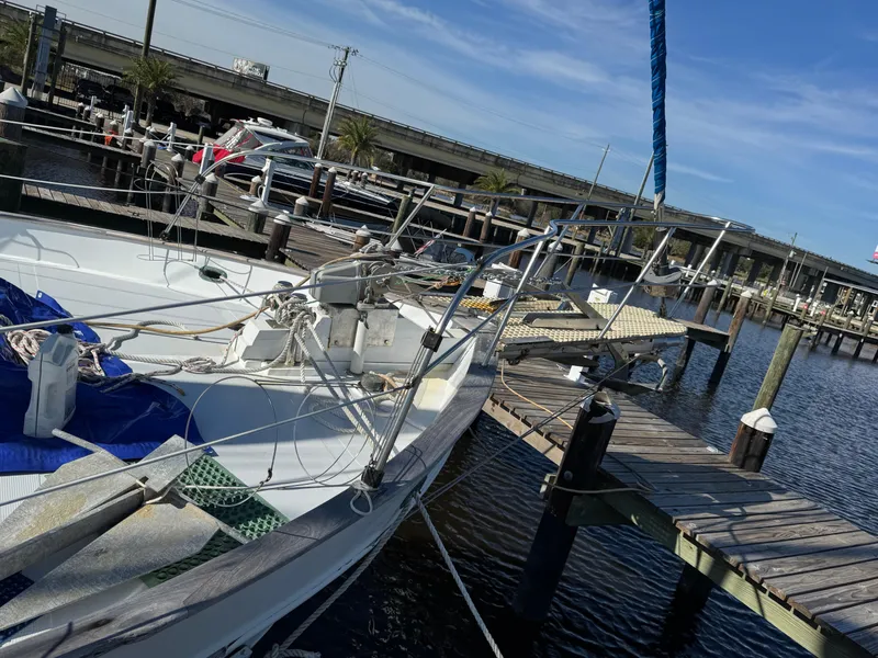 Slide: The Image of 1983 Island Trader Motor Sailor docked at marina, clear sky, wooden pier, nautical ropes visible. - 4