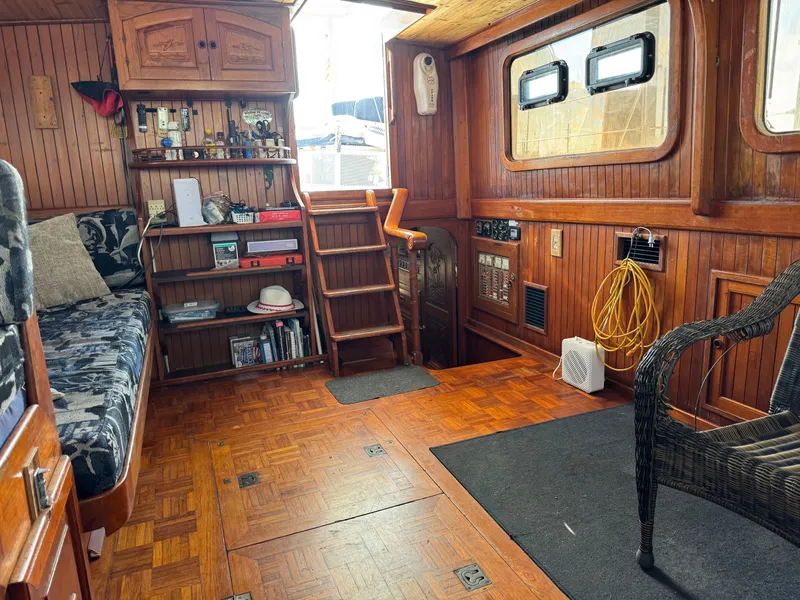 Slide: The Image of Interior of 1983 Island Trader Motor Sailor with wooden decor and cozy seating area. - 9