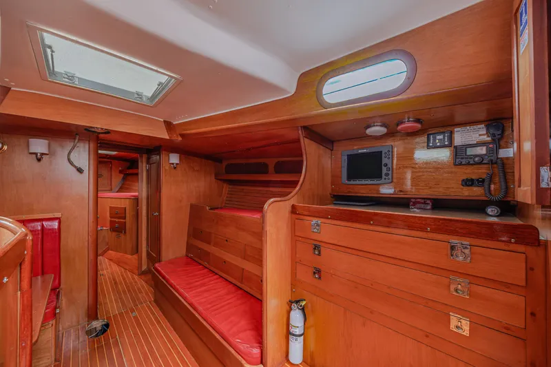 Slide: The Image of Interior of 1972 Hinckley 48 yacht with wooden cabinetry and red seating. - 33