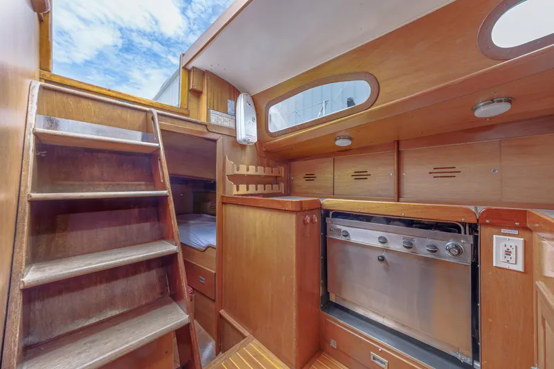 Slide: The Image of Interior of 1972 Hinckley 48 yacht with wooden cabinetry and compact kitchen area. - 35