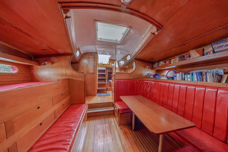 Slide: The Image of Interior of 1972 Hinckley 48 yacht with red seating, wooden finishes, and bookshelves. - 41