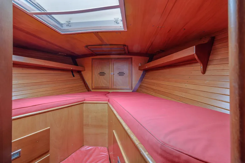 Slide: The Image of Interior cabin of 1972 Hinckley 48 yacht with red cushions and wooden paneling. - 45