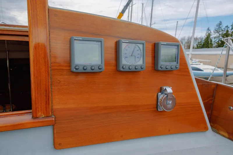 Slide: The Image of Hinckley 48 yacht dashboard with navigation instruments, 1972 model, featuring wooden paneling. - 29