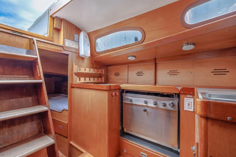 Slide: The Image of Interior of 1972 Hinckley 48 sailboat with wooden cabinetry and compact kitchen area. - 36