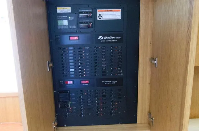 Slide: The Image of Electrical control panel inside 2015 Hatteras 45 Express Sportfish boat, featuring various switches and indicators. - 12