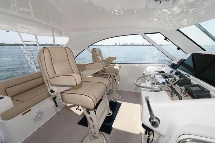 Slide: The Image of 2015 Hatteras 45 Express Sportfish helm with beige seating and ocean view. - 15