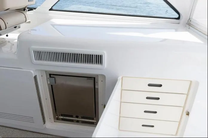 Slide: The Image of 2015 Hatteras 45 Express Sportfish interior with storage drawers and mini fridge. - 19