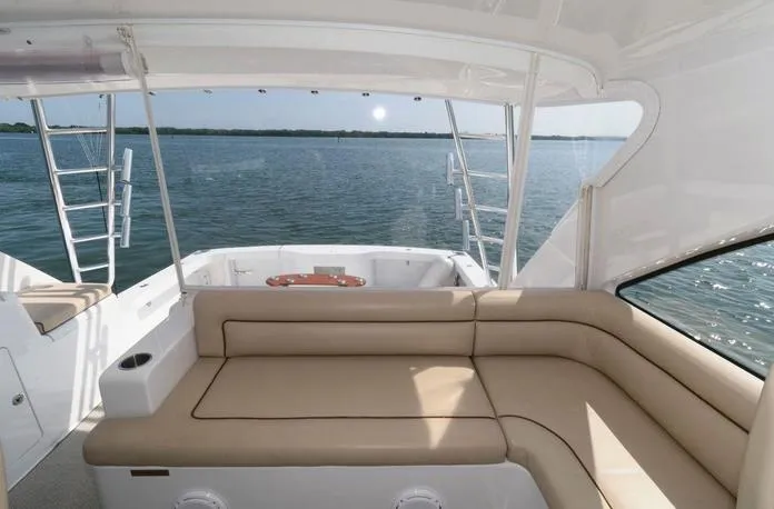 Slide: The Image of 2015 Hatteras 45 Express Sportfish boat with spacious seating, overlooking calm waters. - 21