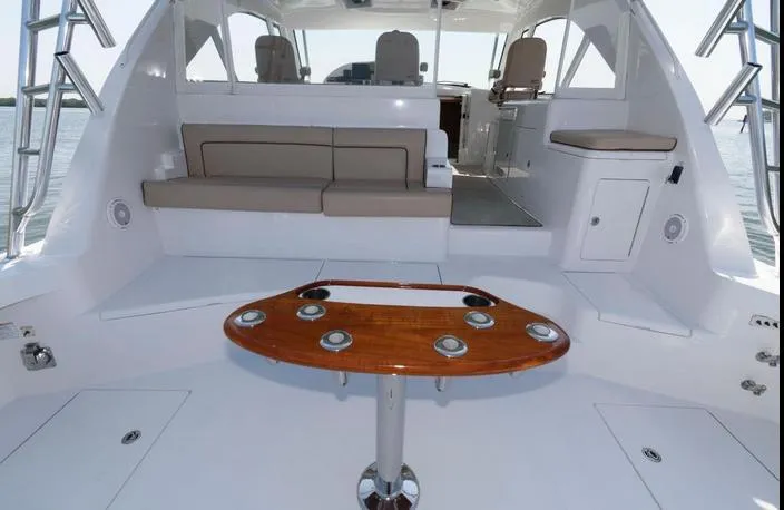 Slide: The Image of 2015 Hatteras 45 Express Sportfish interior with seating and wooden table. - 24