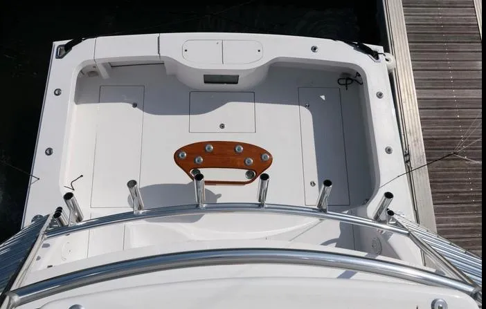 Slide: The Image of 2015 Hatteras 45 Express Sportfish boat deck with fishing rod holders and wooden accents. - 29