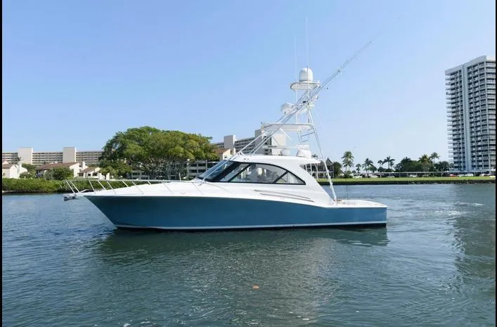 Slide: The Image of 2015 Hatteras 45 Express Sportfish yacht on calm water, cityscape background. - 4