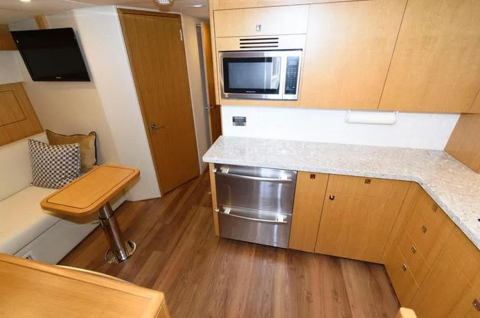 Slide: The Image of Interior of 2015 Hatteras 45 Express Sportfish with modern kitchen and seating area. - 5