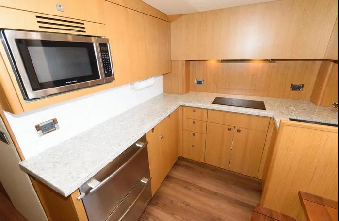 Slide: The Image of Modern kitchen in 2015 Hatteras 45 Express Sportfish with wood cabinetry and stainless steel appliances. - 7