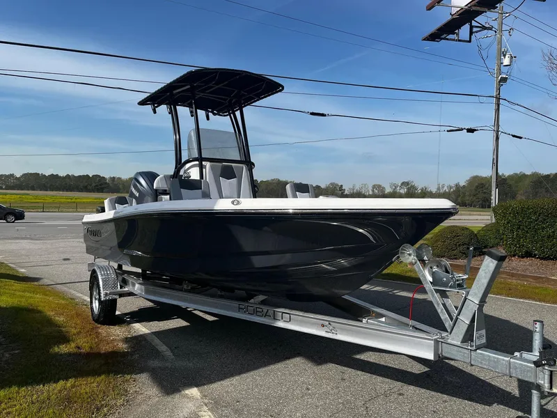Slide: The Image of 2025 Robalo 206 Cayman boat on trailer, parked outdoors under clear sky. - 12