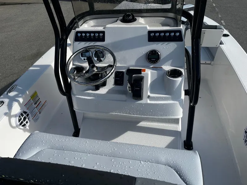 Slide: The Image of 2025 Robalo 206 Cayman boat console with steering wheel and controls, wet with water droplets. - 17