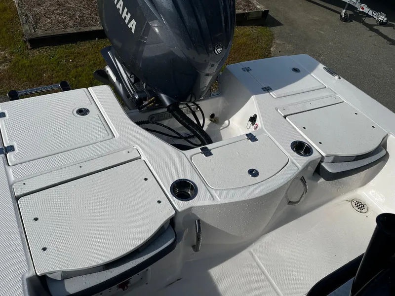 Slide: The Image of 2025 Robalo 206 Cayman boat deck with Yamaha engine, featuring storage compartments and cup holders. - 14