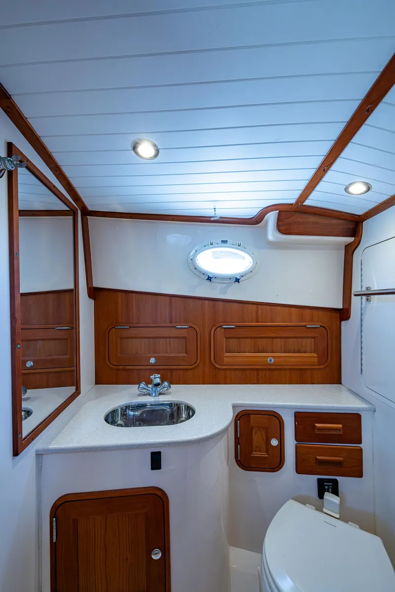 Slide: The Image of 2016 Hinckley Talaria 34 yacht bathroom with wood accents and modern fixtures. - 12