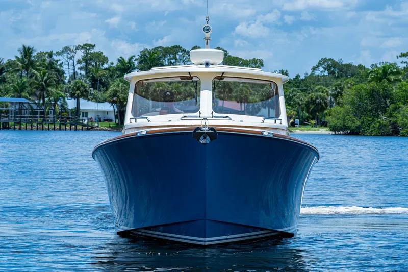 Slide: The Image of 2016 Hinckley Talaria 34 yacht on a serene waterway, surrounded by lush greenery. - 22